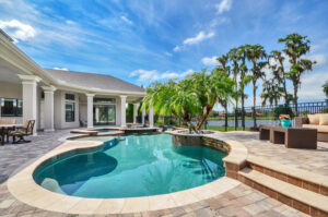 A spacious backyard featuring a custom swimming pool and paved patio, expertly designed by TamLin Homes Inc in Tampa, FL