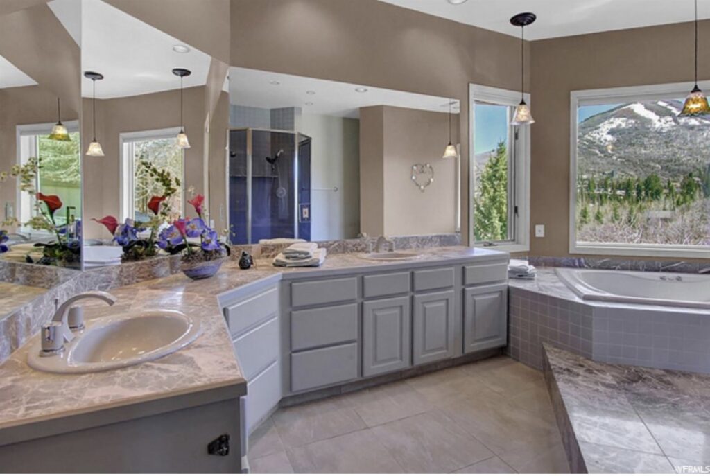 A spacious renovated bathroom featuring a double vanity and large mirrors by Halpin Hands in Williams, OR.