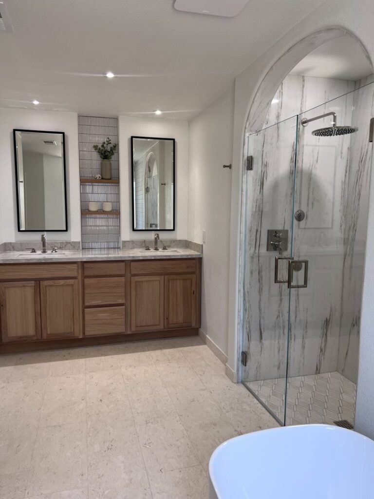 A spacious bathroom renovation with a double vanity and arched walk-in shower by AZ New Bath in Glendale, AZ