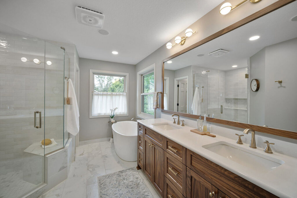 A spacious bathroom remodel featuring a double vanity, freestanding tub, and walk-in shower by J Brothers Design- Build- Remodel, Inc. in Corcoran, MN