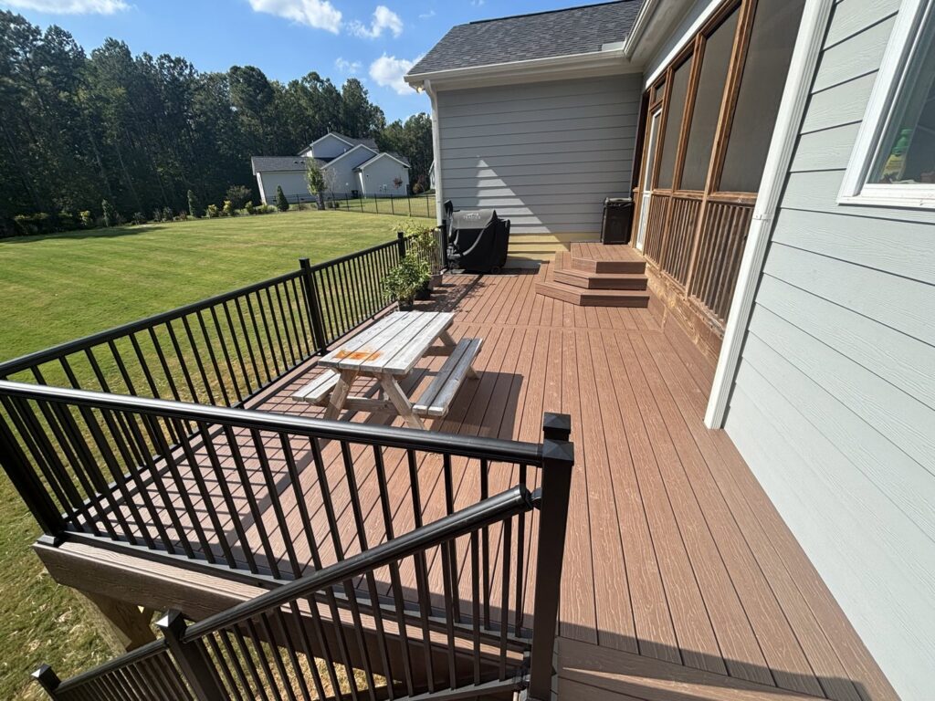 A spacious composite deck with black railings and a picnic table, built by Elite Xteriors NC in Cary, NC.