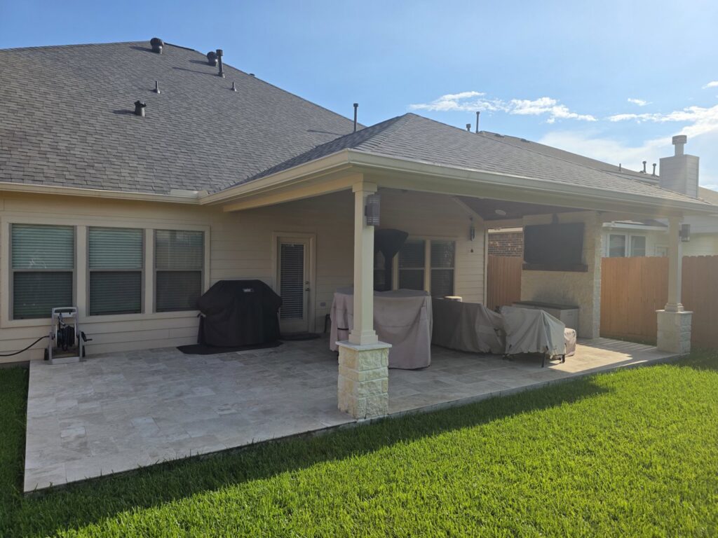 A spacious covered patio with outdoor furniture and a grill by Houston Home Improvements & Construction in Houston, TX