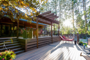 A spacious, finished composite deck featuring a wooden pergola and elegant railing, built by Ridgeline Decks in Spokane, WA.