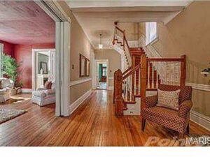 A spacious hallway leading to a wooden staircase and living room, demonstrating home remodeling expertise from Major League Handyman and Remodeling in St. Louis, MO.