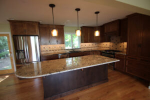 A spacious kitchen remodel with wooden cabinets, granite countertops, and a large island by Shafer Construction, LLC in Bethlehem, PA.