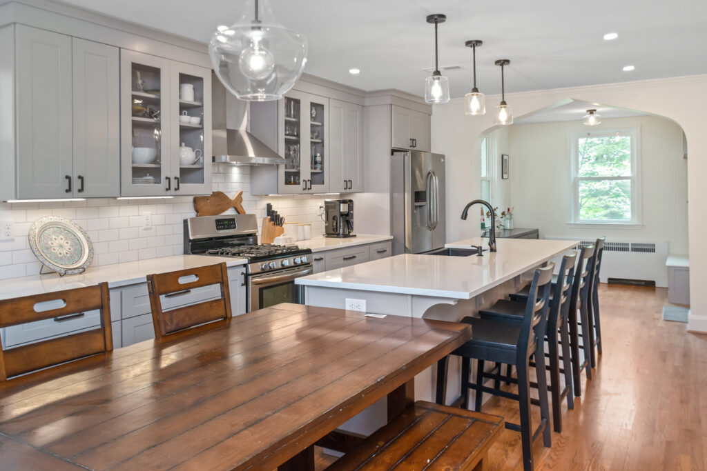 A spacious kitchen remodel with grey cabinets, a large island, and dining area by Total Craftsmen in Towson, MD