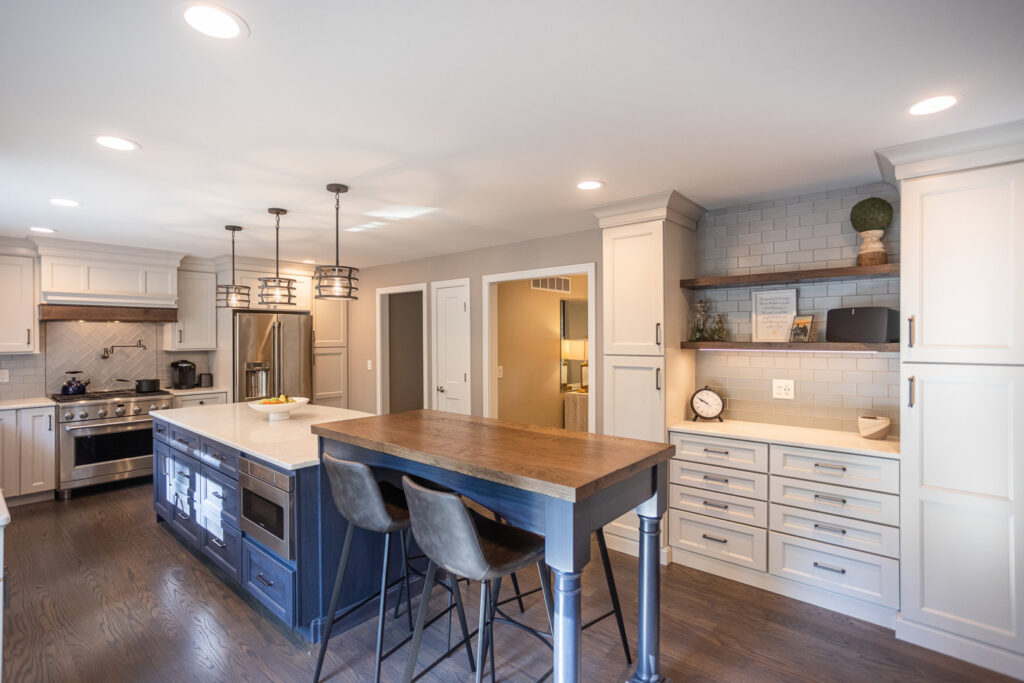 A spacious kitchen remodel showcasing a large island, elegant pendant lights, and light-colored cabinetry by Legacy Builders Group in Cincinnati, OH.
