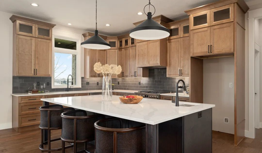 A spacious kitchen remodel showcasing light wood cabinets and a dark island by Slater Cabinets and More in Springfield, MO.