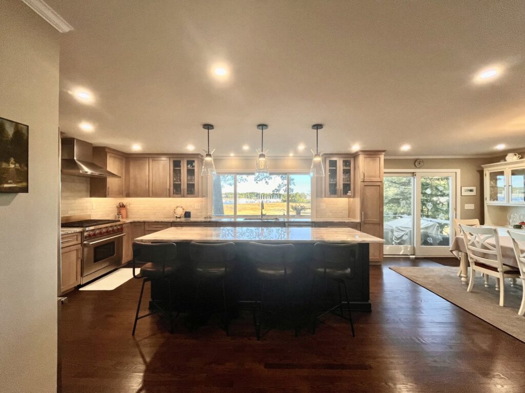Spacious kitchen renovation with a large island, wood cabinets, and a view of the water by Byrd's Contracting, LLC in Bristol, CT.