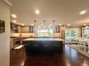 Spacious kitchen renovation with a large island, wood cabinets, and a view of the water by Byrd's Contracting, LLC in Bristol, CT.