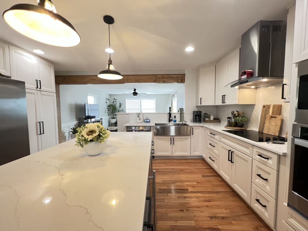 A spacious kitchen renovation featuring white shaker cabinets, a large island, and hardwood floors by Home Style Improvement in Frederick, MD.