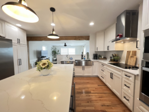 A spacious kitchen renovation featuring white shaker cabinets, a large island, and hardwood floors by Home Style Improvement in Frederick, MD.
