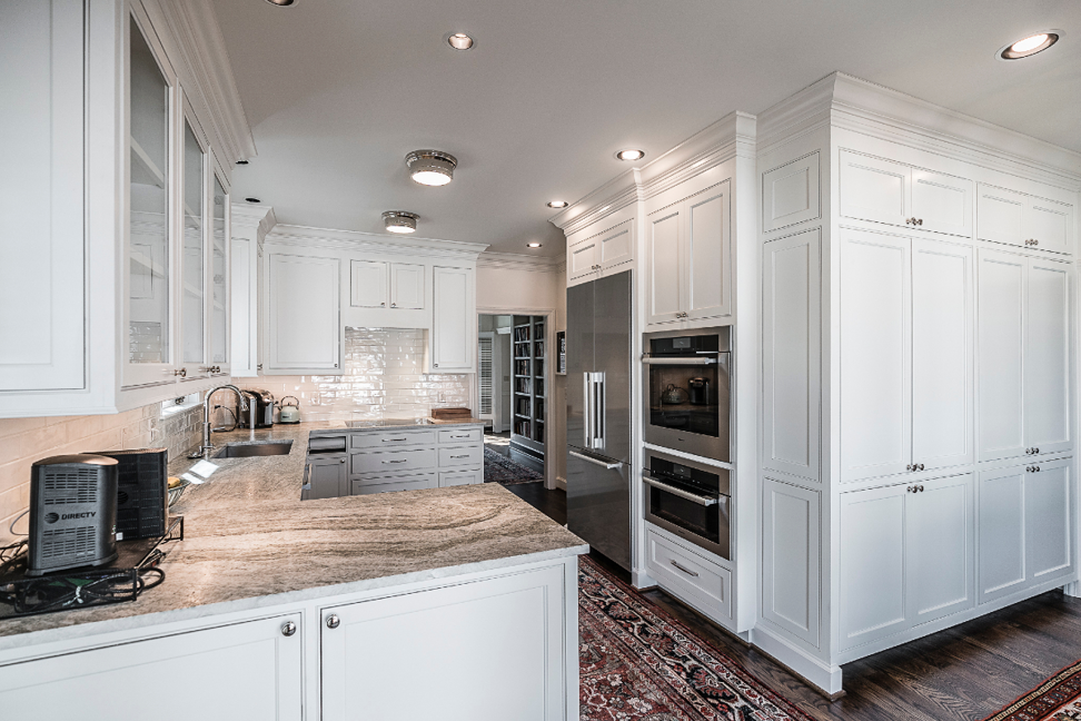 A spacious kitchen with white shaker cabinets, granite countertops, and built-in appliances, a project by Nova Constructors in Nashville, TN.