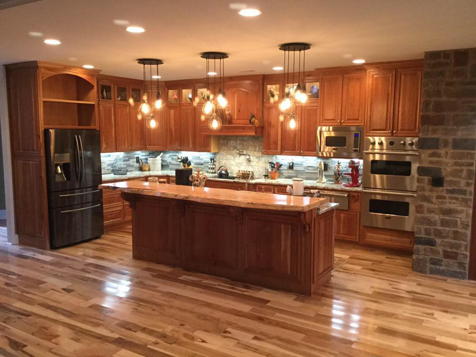 A spacious kitchen featuring warm wooden cabinets, a large island, and modern appliances by Cherokee Cabinet in Athens, GA.