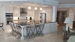 Spacious modern kitchen with white cabinets and large island by Charter Bay Home Builders in Tampa, FL