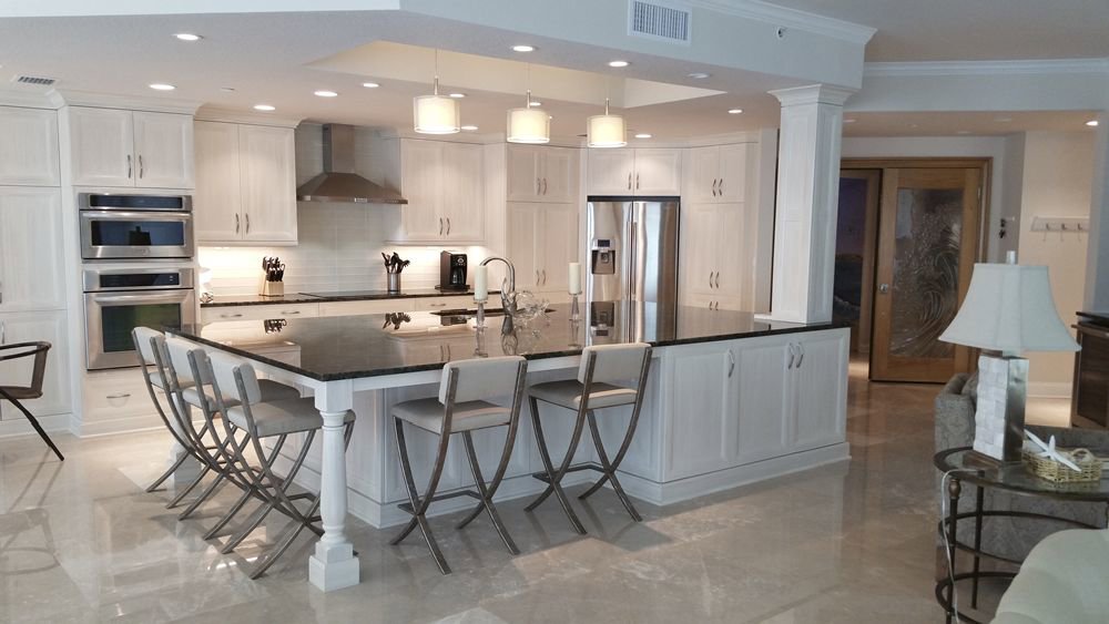 Spacious modern kitchen with white cabinets and large island by Charter Bay Home Builders in Tampa, FL