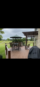 A spacious outdoor deck complete with patio furniture and an umbrella, built by Nader Builders in Ann Arbor, MI.