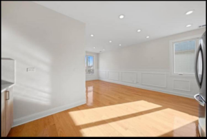 A spacious, newly renovated living area with hardwood floors and recessed lighting by Revival Home Remodeling in Chicago, IL.