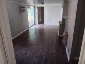 A spacious renovated room featuring new tile flooring and painted walls, completed by Joel's flooring & Handyman services in Roy, UT.