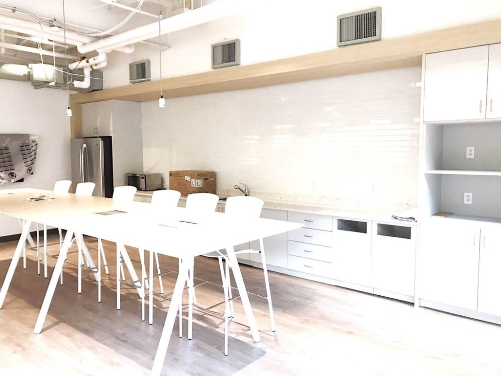 A spacious white commercial breakroom with new cabinets and countertops installed by J. Forrest Development, LLC in Matthews, NC.