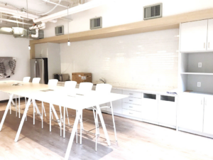 A spacious white commercial breakroom with new cabinets and countertops installed by J. Forrest Development, LLC in Matthews, NC.