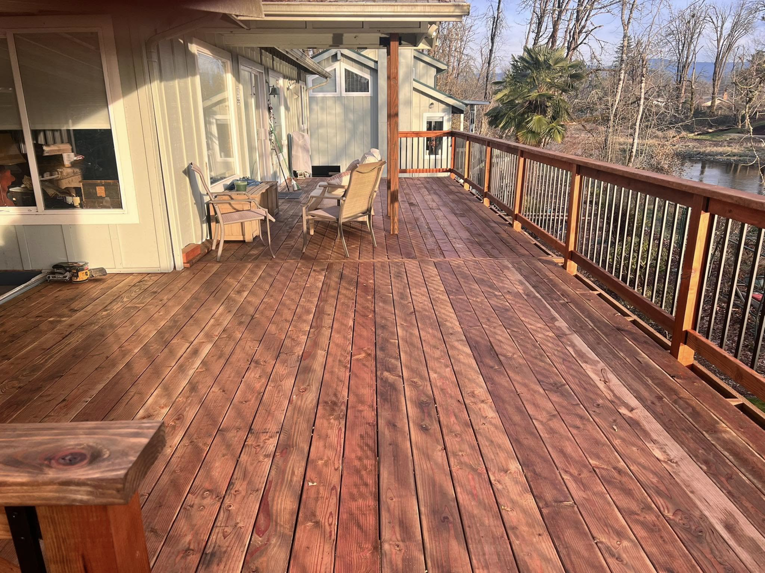 A spacious outdoor wooden deck with railings, installed by One Up construction llc in Springfield, OR.
