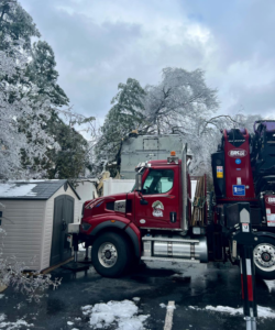 A specialized red tree service truck with a crane attachment ready for work by Ogle Tree Service LLC in Nashville, TN.