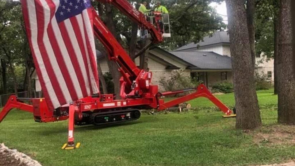 A red spider lift with an American flag, used by A. Matt Tree Service for tree services in Fort Worth, TX.