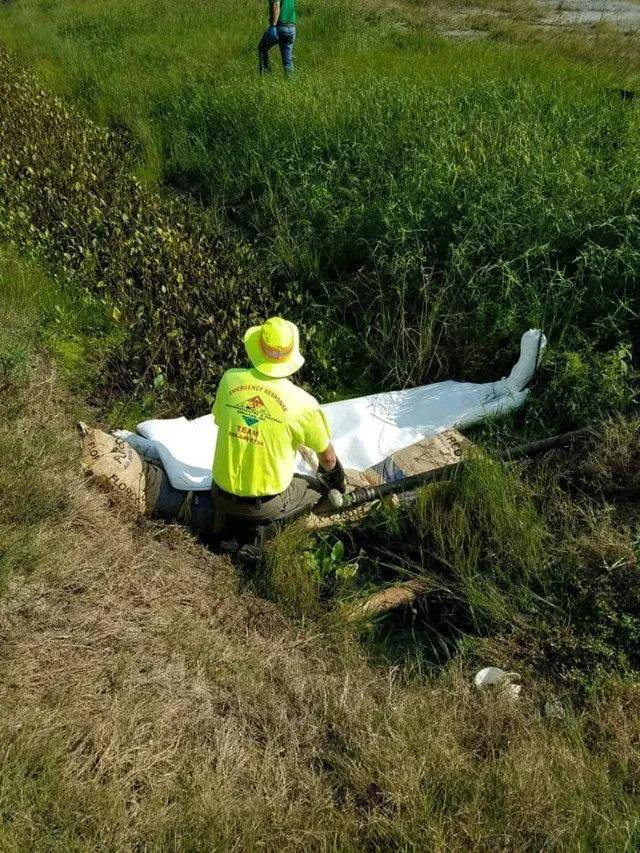A worker deploying absorbent booms during a spill response operation by Environmental & Hazmat Services in Ashford, AL.