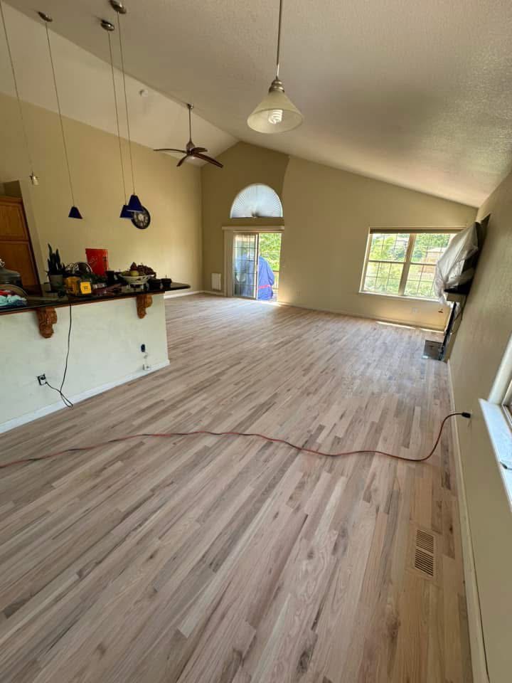 A spiral staircase with unfinished wooden treads and tools, showing work in progress by IHS flooring LLC in Brighton, CO.