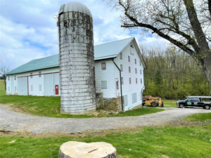 A Spoutco Home Improvements truck and equipment parked at a barn and silo job site in York, PA.