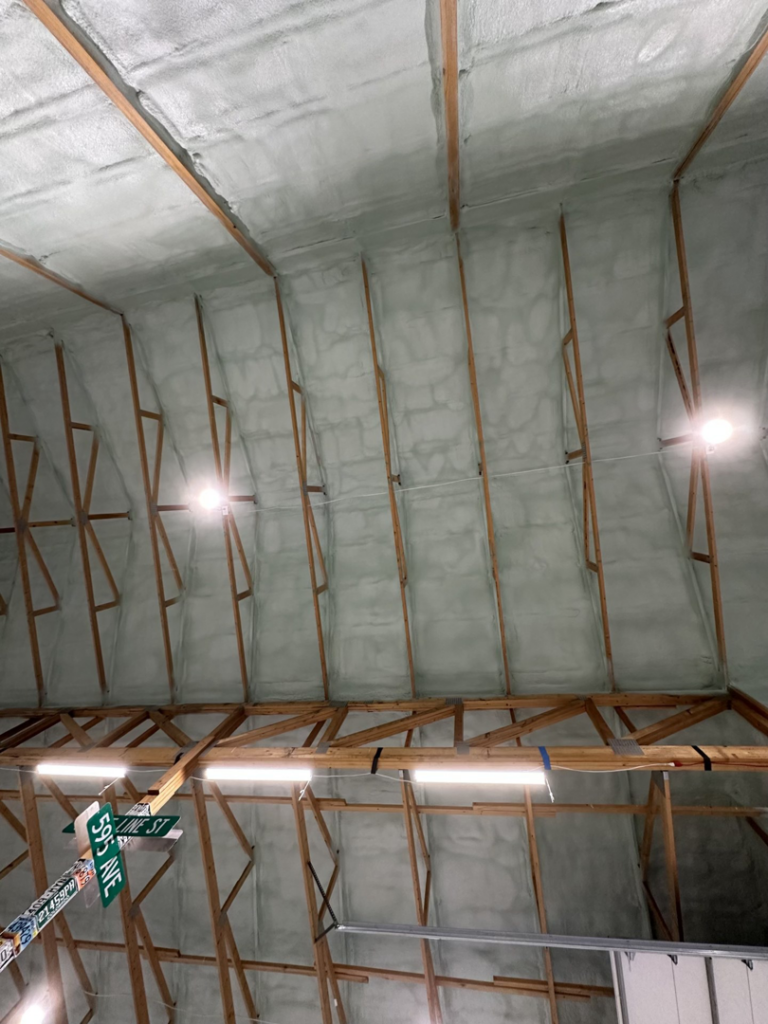 Spray foam insulation applied to the ceiling of a large structure by Tumbarello Insulation in Peyton, CO.