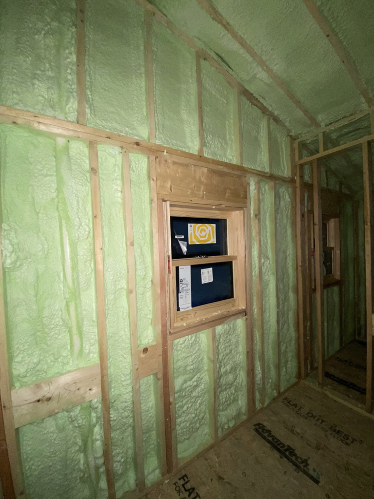 Spray foam insulation applied to a framed room with a window by Albany Spray Foam Solutions in Coxsackie, NY