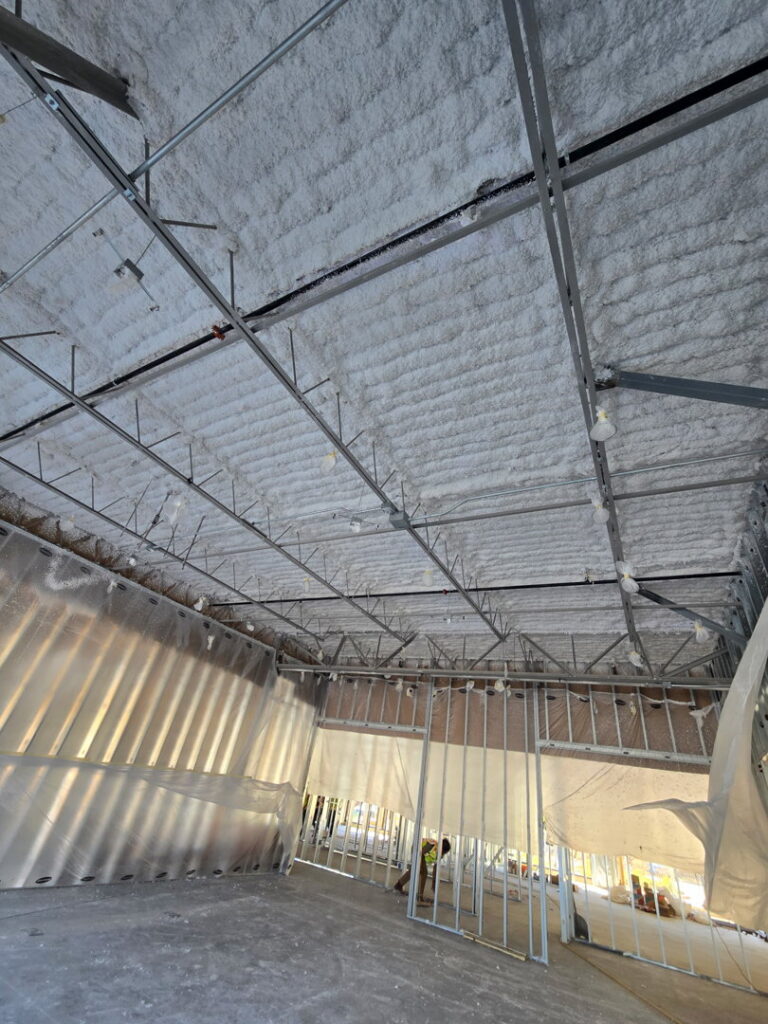 Spray foam insulation being installed on a ceiling by Bell SPI - Shamrock Painting in Denver, CO.