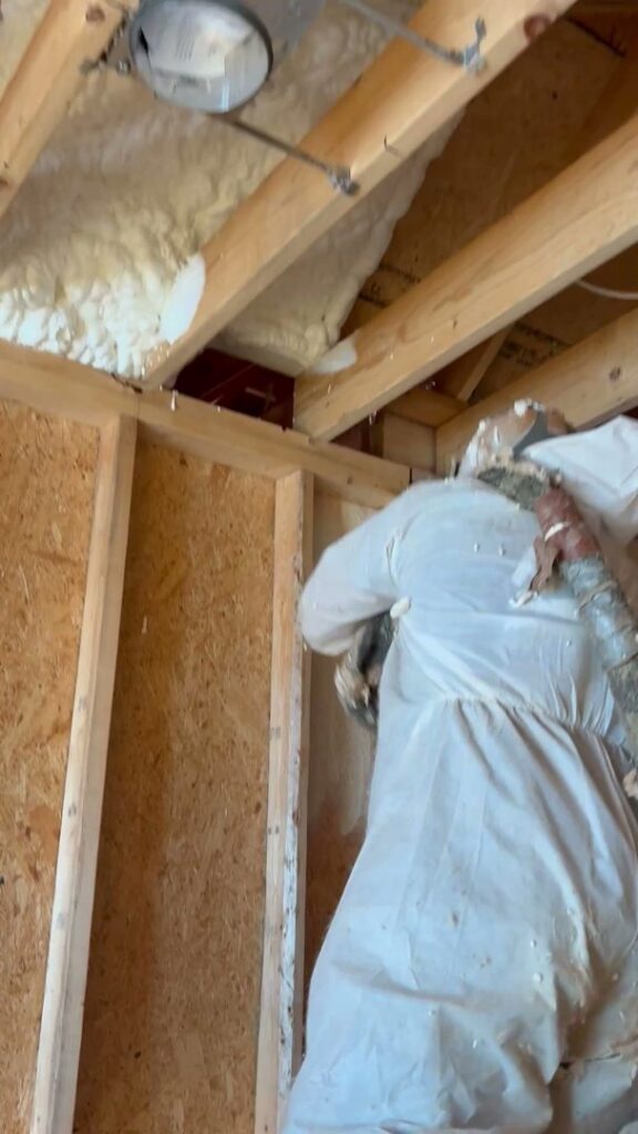 A technician applying spray foam insulation in a wall cavity or attic by Koala Insulation of Charlotte, NC