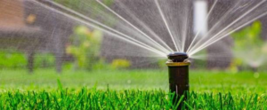 A working sprinkler system watering a lush green lawn by C & E Sprinkler, your handyman in Spokane, WA.