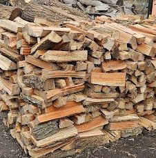 A large pile of neatly stacked firewood from William "Rusty" Ruskey Tree Service in Newport News, VA.