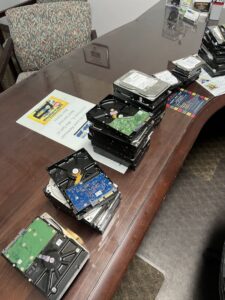 Stacks of computer hard drives on a table, representing e-waste removal services offered by Junk Solutions in Ogden, UT.