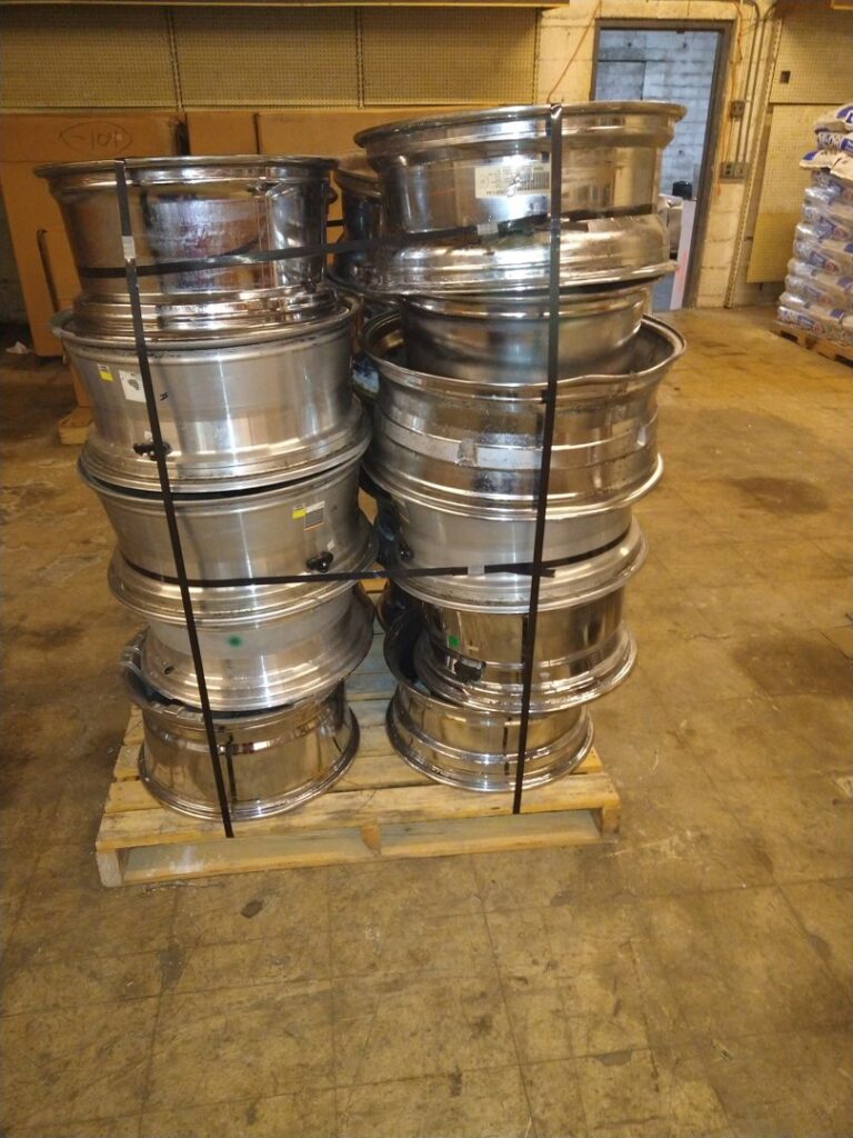 Stacks of metal wheel rims on pallets for scrap metal recycling at Mid Atlantic Recycling Solutions, LLC in Norfolk, VA.