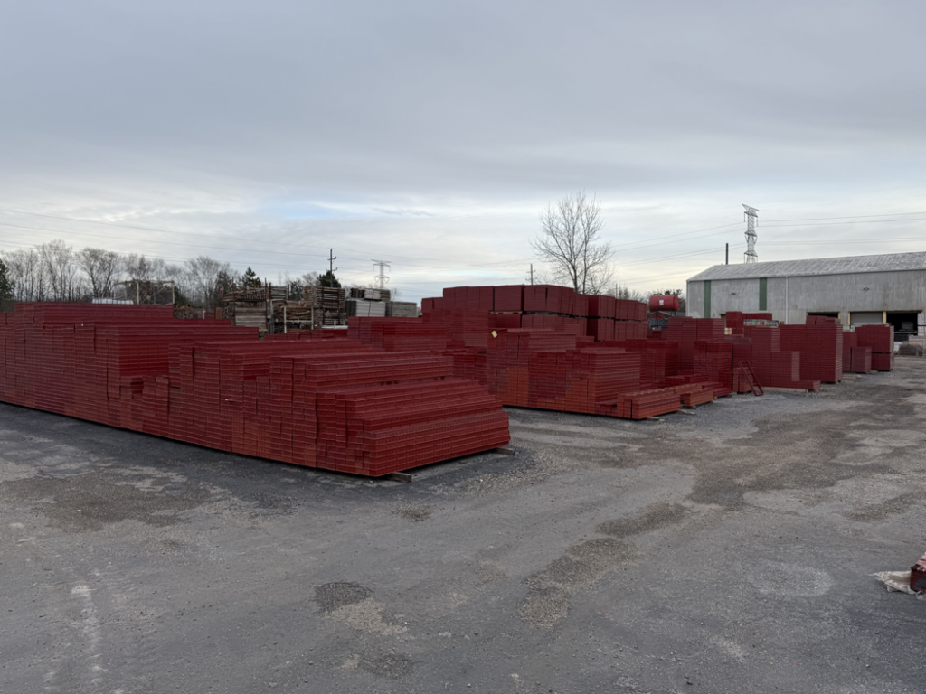 Large stacks of red concrete forms in the yard at Forming America, LLC in West Chicago, IL