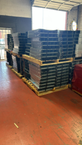Large stacks of server racks and electronic equipment on pallets in a facility of E-Z Money Recycling LLC in Phoenix, AZ.