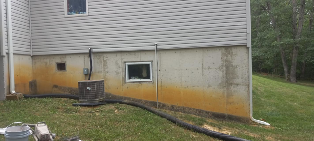 A stained house foundation needing cleaning or painting, a service offered by Picture Perfect Painting and Wallpapering Inc. in O Fallon, MO.