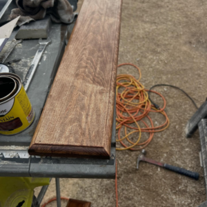 Stained wood trim on a workbench with a can of wood stain, showing finishing work by TS ELDER LLC in Phoenix, AZ