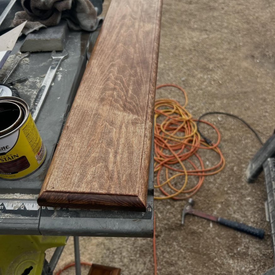 Stained wood trim on a workbench with a can of wood stain, showing finishing work by TS ELDER LLC in Phoenix, AZ
