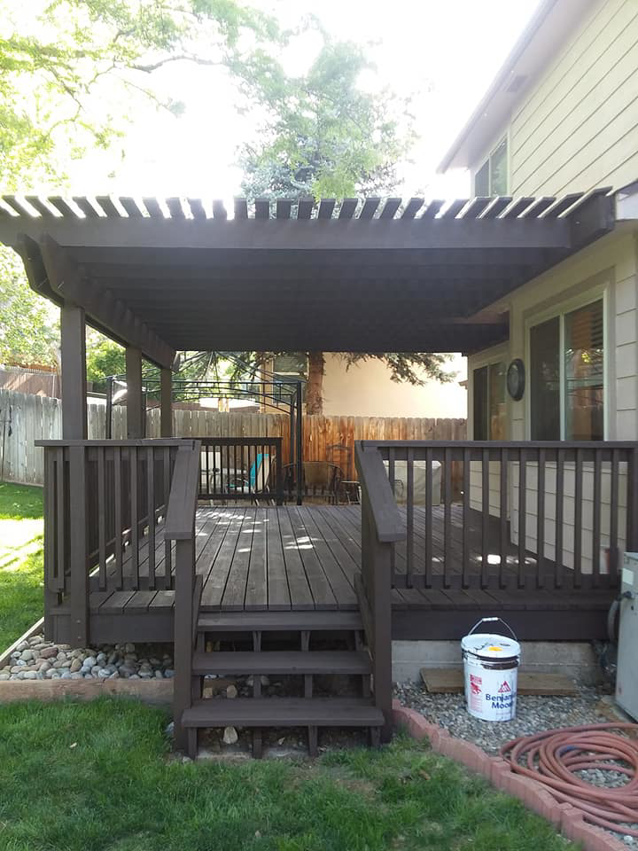 A stained wooden deck with stairs and a paint bucket, showcasing work by Brauny Home Services, LLC in Arvada, CO