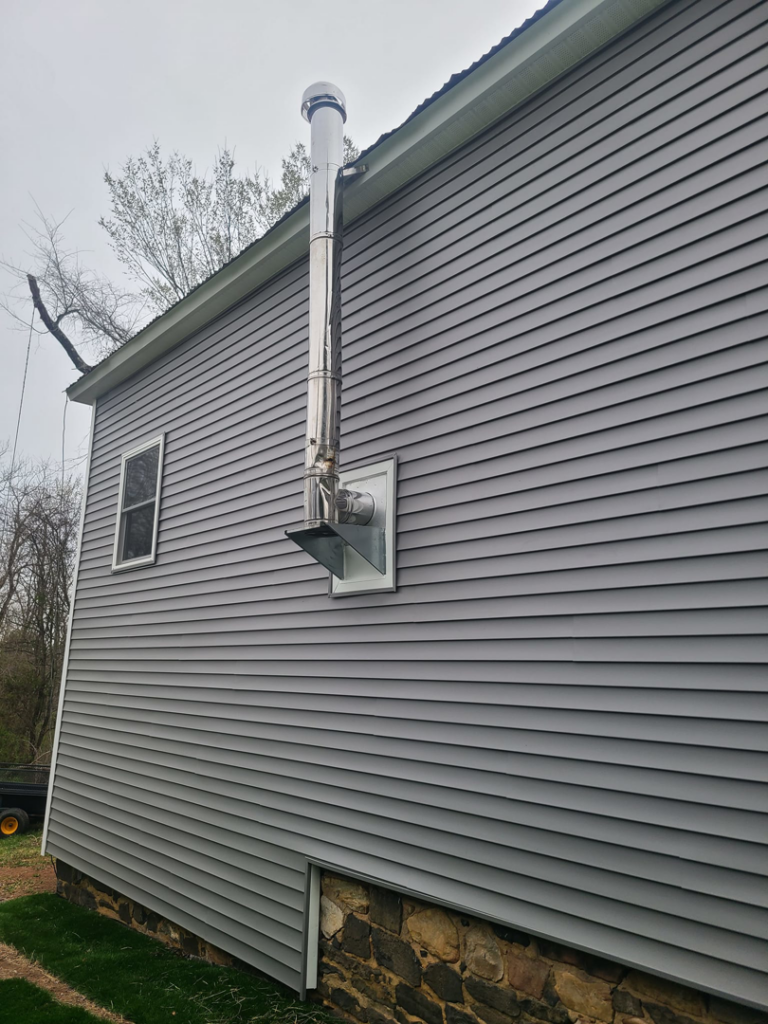 Newly installed stainless steel chimney flue on a building by Jos Construction LLC in Trenton, NJ.