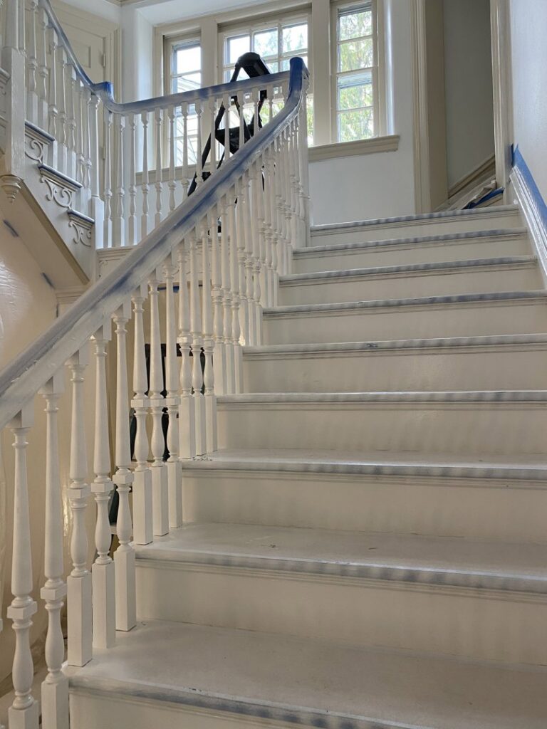 Staircase balusters and handrail taped for painting during a renovation by S-G General Contracting LLC in Philadelphia, PA.