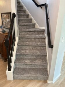 A newly carpeted staircase with updated railings installed by D E Custom Floors in Waukesha, WI.