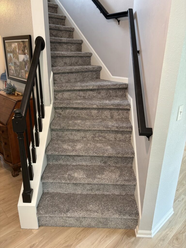 A newly carpeted staircase with updated railings installed by D E Custom Floors in Waukesha, WI.
