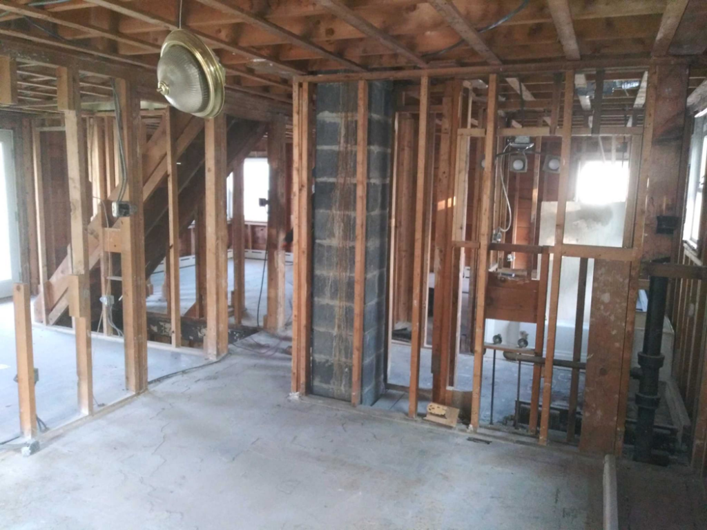 A staircase under construction or renovation, showing exposed framing and partially painted steps by J-BO Enterprises, Inc in Wilmington, MA.